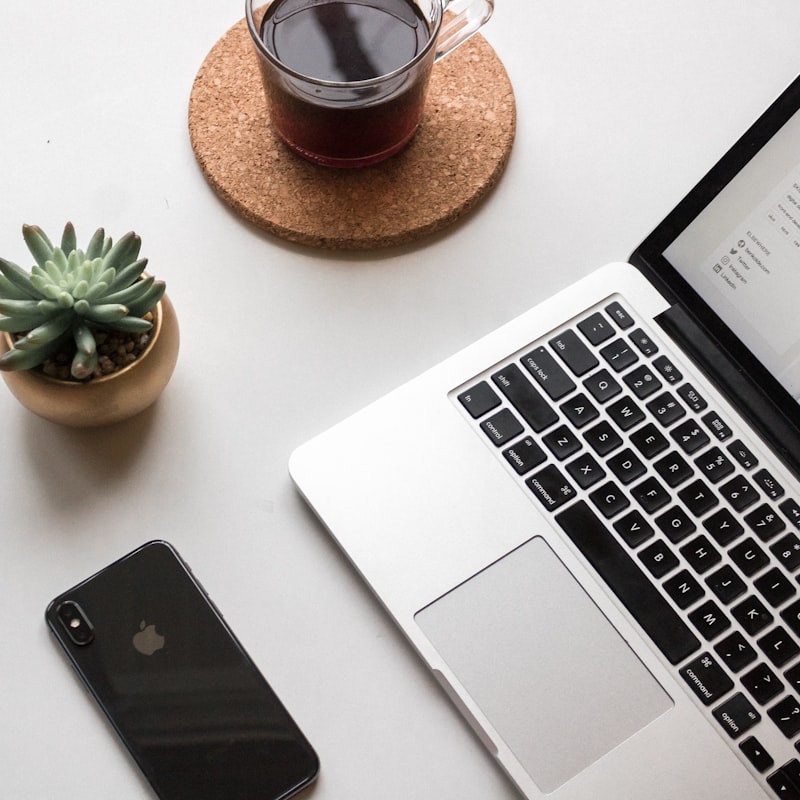 Clean desk setup with phone and laptop, representing an organised property agent system that runs without manual data entry