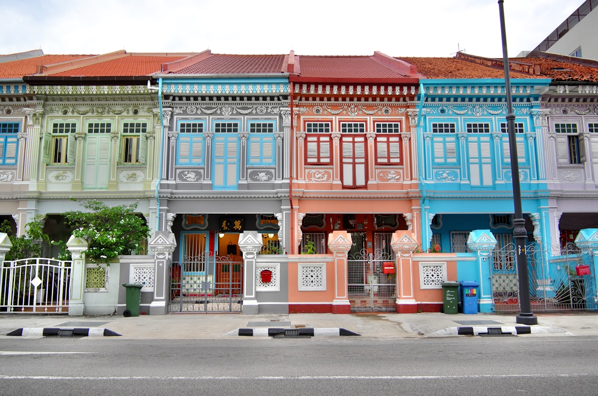 Row of multicoloured Peranakan terrace houses on a Singapore street with ornate architectural details