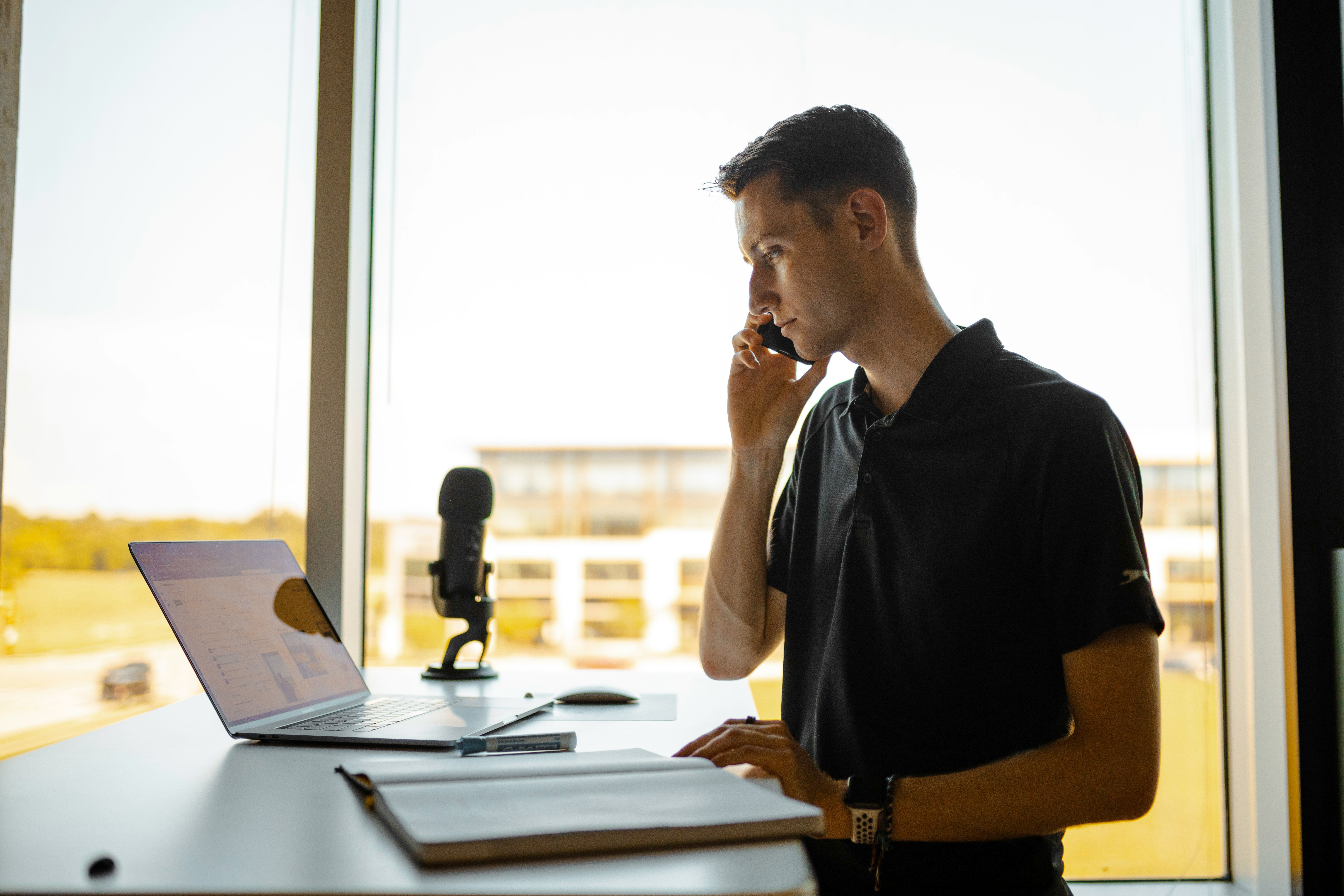 Property agent making a follow-up call at his desk with laptop open, representing systematic lead tracking